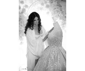 Margarita Looking Affectionately at Her Wedding Dress - Fuss Photography