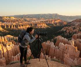 Photographer setting up tripod at Bryce Canyon during golden hour