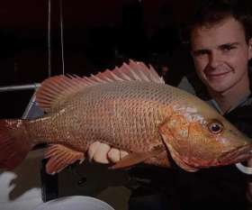 Holding The Fish He Caught - True Blue Fishing