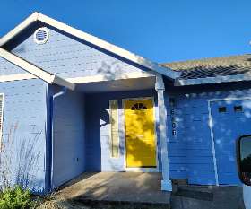 A light blue home with a sunny yellow front door | Itech Painting Professionals